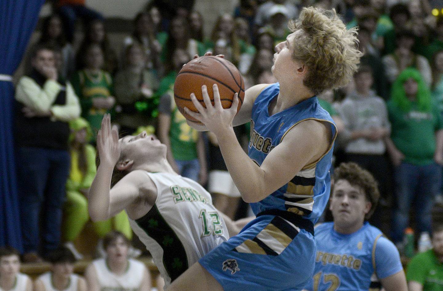 Marquette's Griffin Walker flies into Seneca's Braden Ellis (12) during the Marquette Christmas Tournament championship game in Ottawa on Thursday.