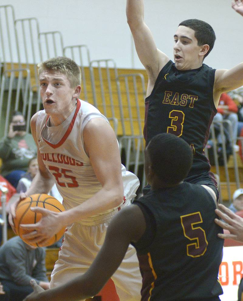 Streator’s Joseph Hoekstra pulls down this rebound ahead of East Peoria’s Kingston Weatherspoon and Cole Dubois during the 2nd period Wednesday at Streator.