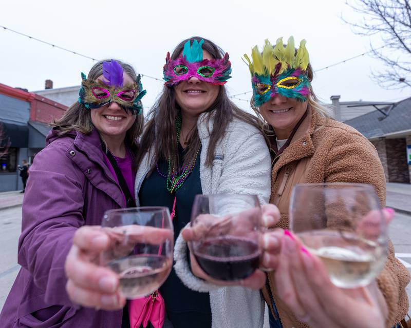 Faustin Jackson, Shari Thompson and Kasey Roth pose for photo holding wine glasses at the wine walk on Feb. 14, 2026 on Mill Street in Utica.