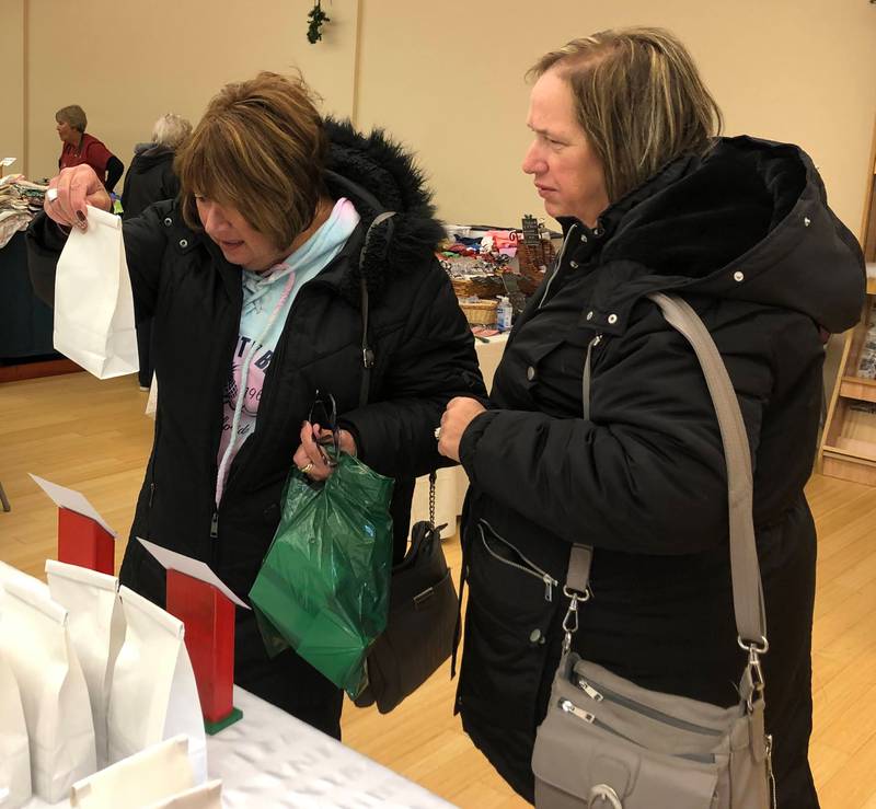 Linda Halberg and Peggy Carr check out the large cookie selection with options from around the world at the Christkindlmarket in Princeton on Saturday, Nov. 19, 2022.