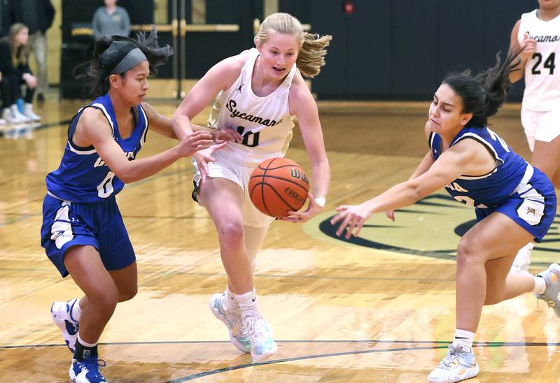 Sycamore’s Lexi Carlsen drives between Geneva's Riley Hasegawa (left) and Leah Palmer during their game Monday, Nov. 14, 2022, at Sycamore High School.