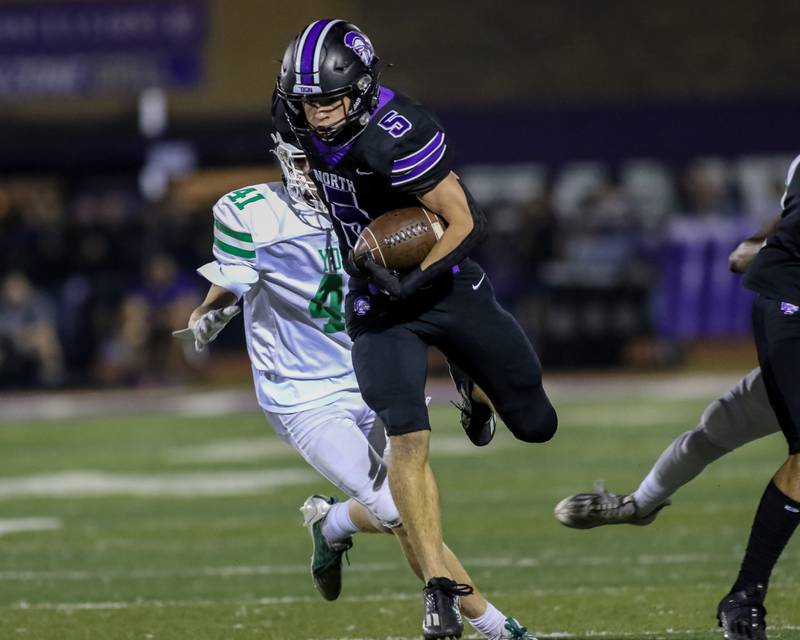 Downers Grove North's Owen Thulin (5) gains yards after a short catch during football game between York at Downers Grove North.  Sept 29, 2023.