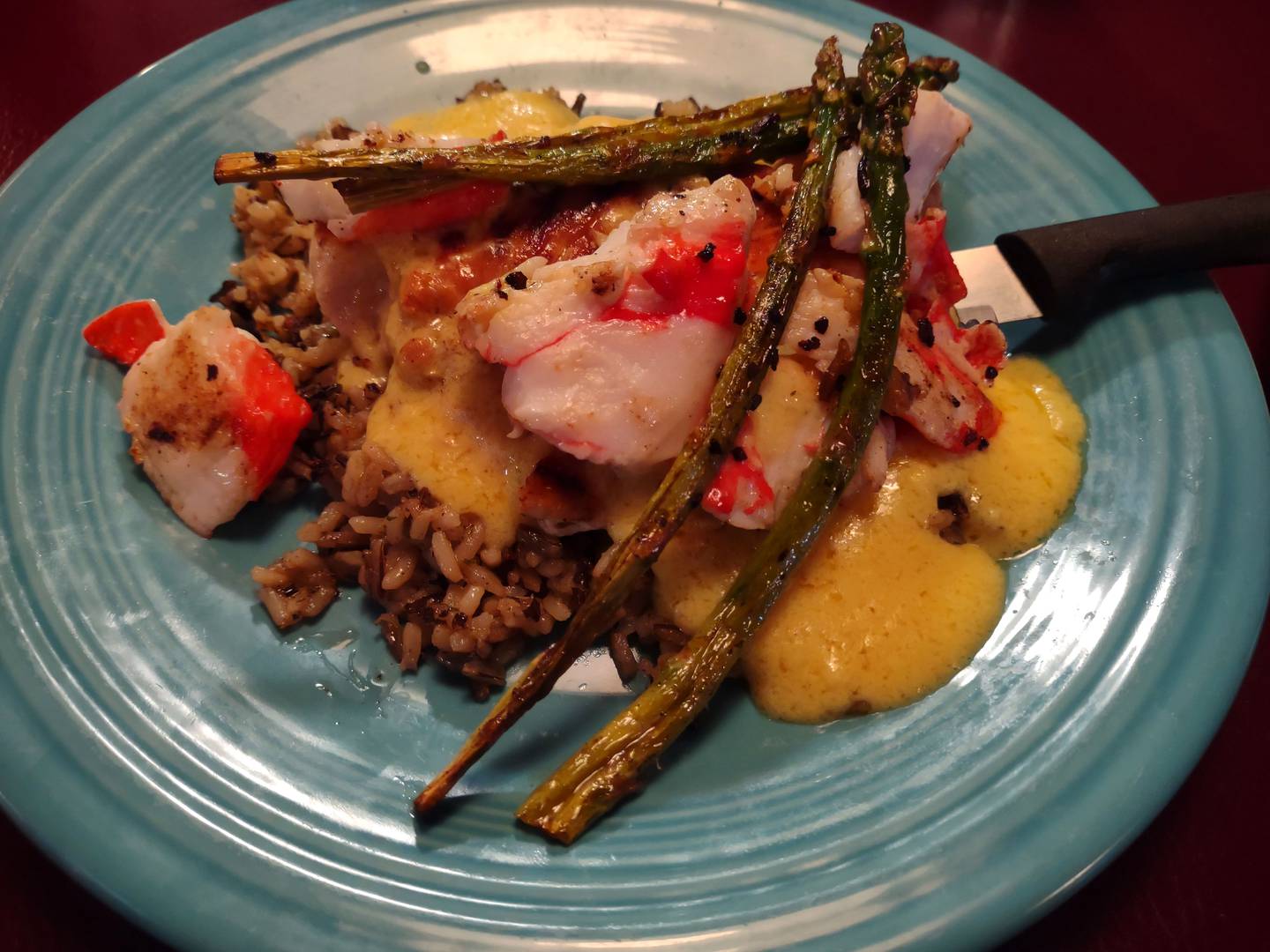 A grilled chicken breast is concealed beneath a velvety sauce, chunks of crab meat and asparagus spears in the chicken oscar at Softails Bar and Grill. The meal is served over a bed of rice.