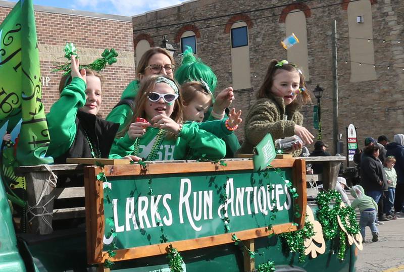 Kids ride the Clarks Run Antiques float during the St. Patrick's Day parade on Saturday, March 16, 2024 downtown Utica.