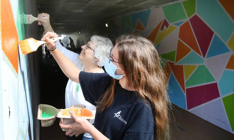 Kalyn Wackerlin, from Waterman, and her grandma Marcia Wilson, from Sycamore, paint a couple of the shapes in the new mural Tuesday on the Hopkins Park pedestrian underpass below Sycamore Road. The DeKalb Public Works Department created the project with hopes that the underpass, which has been a common target for graffiti in the past, will be left alone. Once completed the mural will be painted with a protective coating that will make clean up easy.