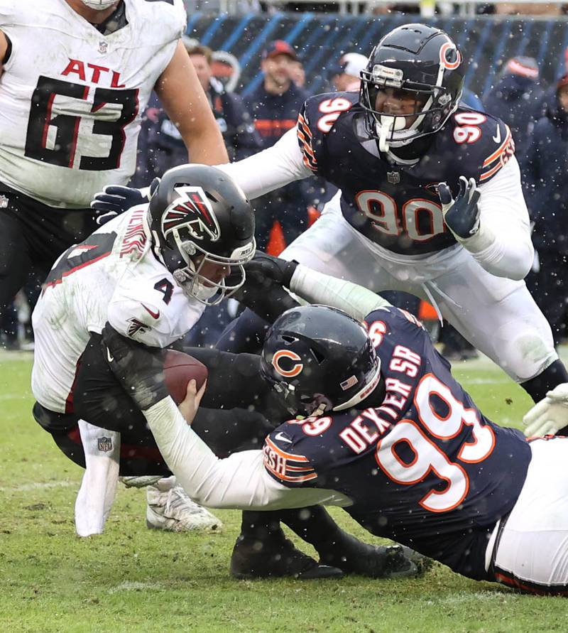 Chicago Bears defensive tackle Gervon Dexter Sr., defensive end DeMarcus Walker and defensive end Dominique Robinson sack Atlanta Falcons quarterback Taylor Heinicke during their game Sunday, Dec. 31, 2023, at Soldier Field in Chicago.