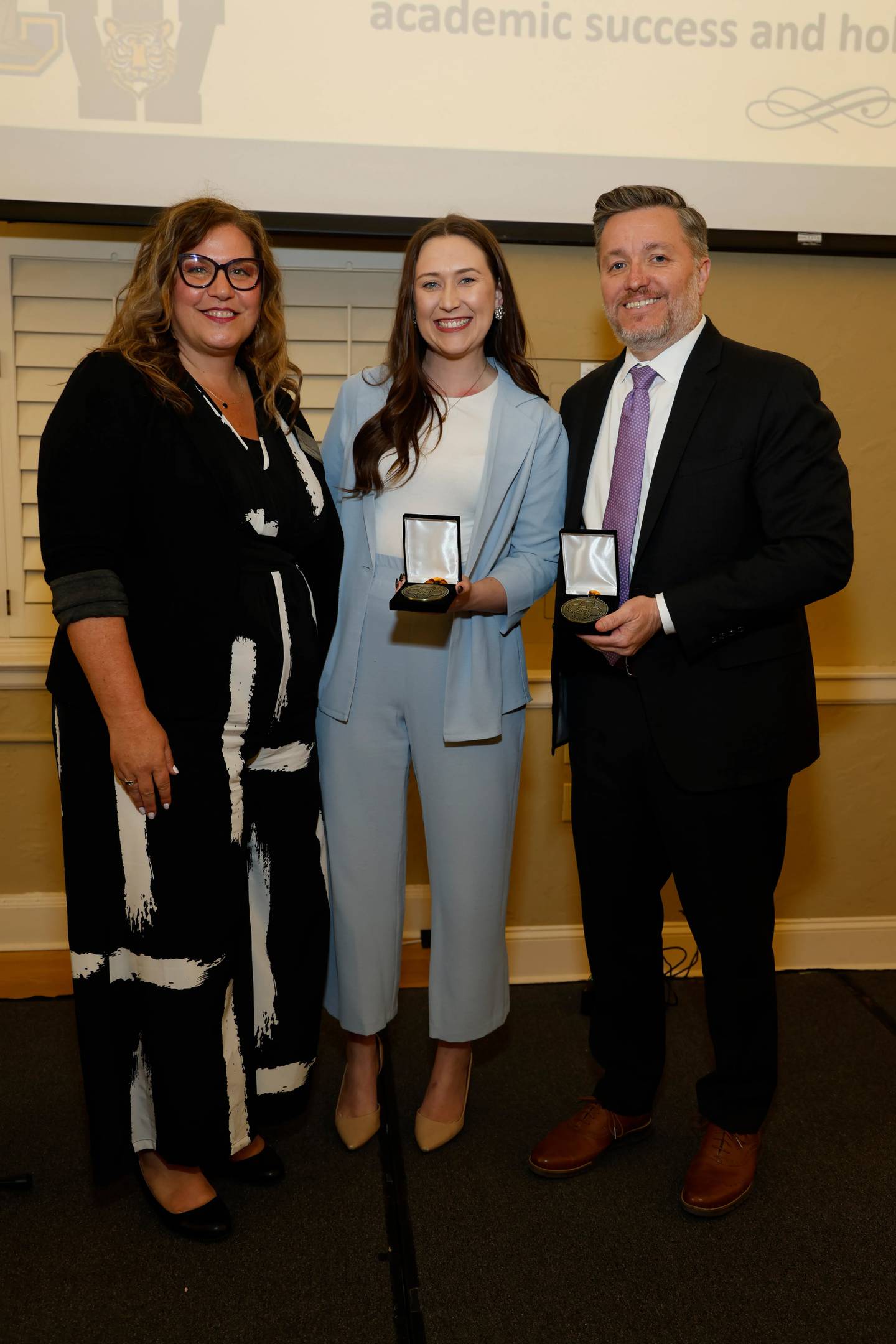 Joliet Township High School District 204 Superintendent Dr. Karla Guseman presents the Superintendent's Medallion to Will County Center for Economic Development Vice President of External Affairs Kayla Sorensen and President and CEO Doug Pryor at the Salute to Service event on April 10, 2025.