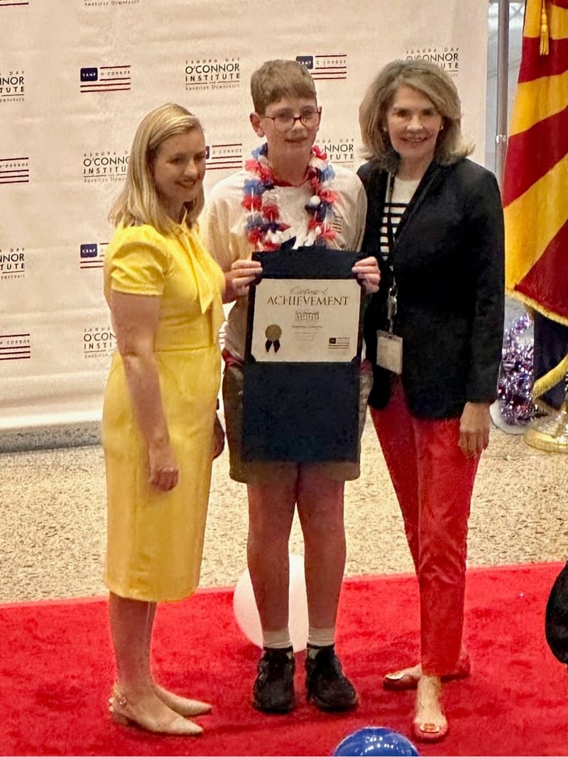 Andrew Olivero of Peru receives a certificate of achievement from Phoenix Mayor Kate Gallego (left) and Sarah Suggs (right), President of the Sandra Day O’Connor Institute for American Democracy.