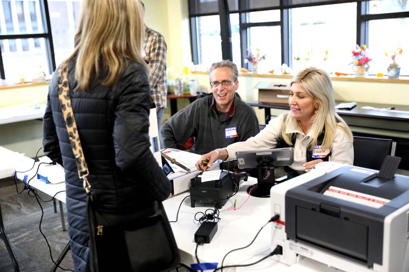 Election Judges Tom Mysilwiec and Laurie Hurst help voter Natalie Wilson of Downers Grove during the Consolidated Election at the Downers Grove Township offices polling place on Tuesday, April 3. 2023.