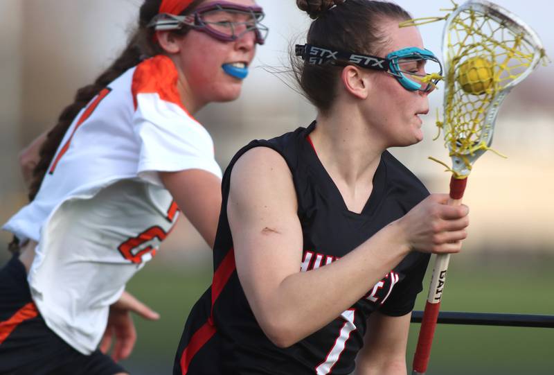 Crystal Lake co-op’s  Anna Starr, back, keeps pace with Huntley’s Aubrie Rohrbacher, front, in varsity girls lacrosse on Friday, April 18, 2025, at Metcalf Field on the campus of Crystal Lake Central High School in Crystal Lake.