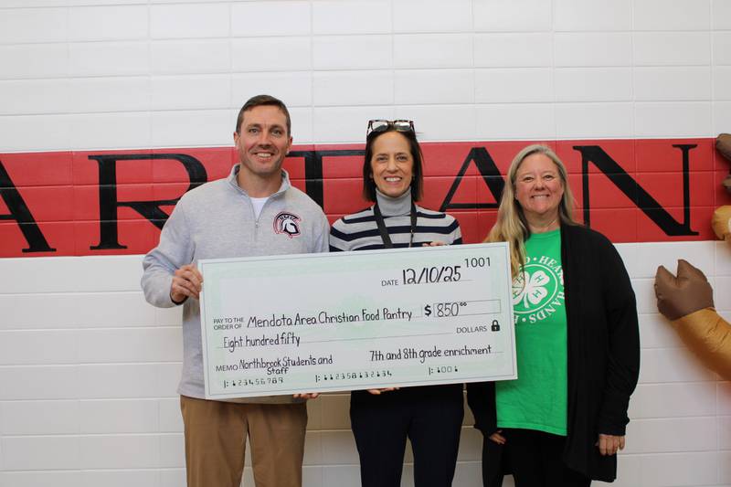 Brandon Scheppers, Sarah Henkel, and Shasta Hladovcak present an $850 donation to the Mendota Area Christian Food Pantry.