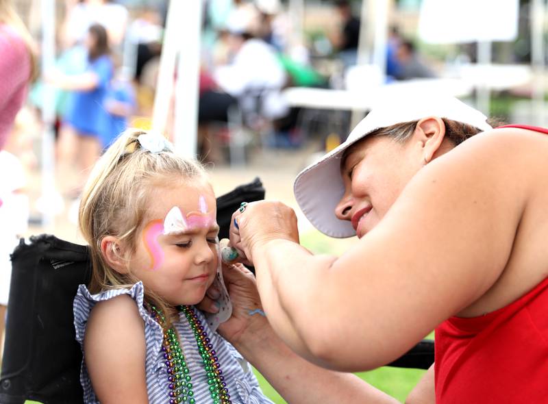 Mia Hosler, 3, has her face painted by Jennifer Thompson of Cherry Berry Blast Facepainting during the annual Swedish Days Kids’ Day on Friday, June 20, 2025 at the Geneva Public Library in Geneva.