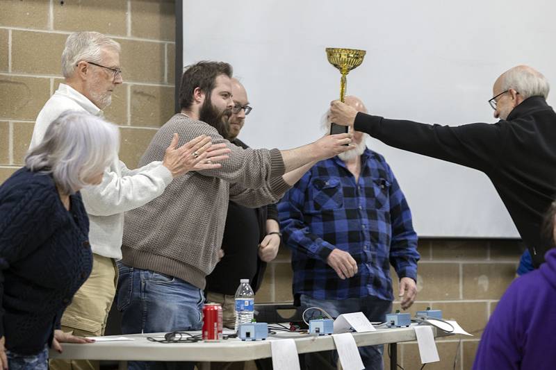Tom Wadsworth hands the QC Knowmads their trivia trophy Saturday, Feb. 7, 2026, at The Stupor Bowl. The event is a fundraiser for Dixon Public Schools.
