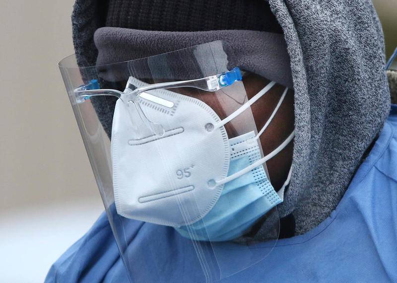 Adebayo Adeniyan, a phlebotomist from HR Support, is using all the recommended personal protective equipment as he takes samples from patrons for testing on a cold Tuesday afternoon at the COVID-19 testing location in the parking lot at the Kishwaukee Family YMCA in Sycamore.