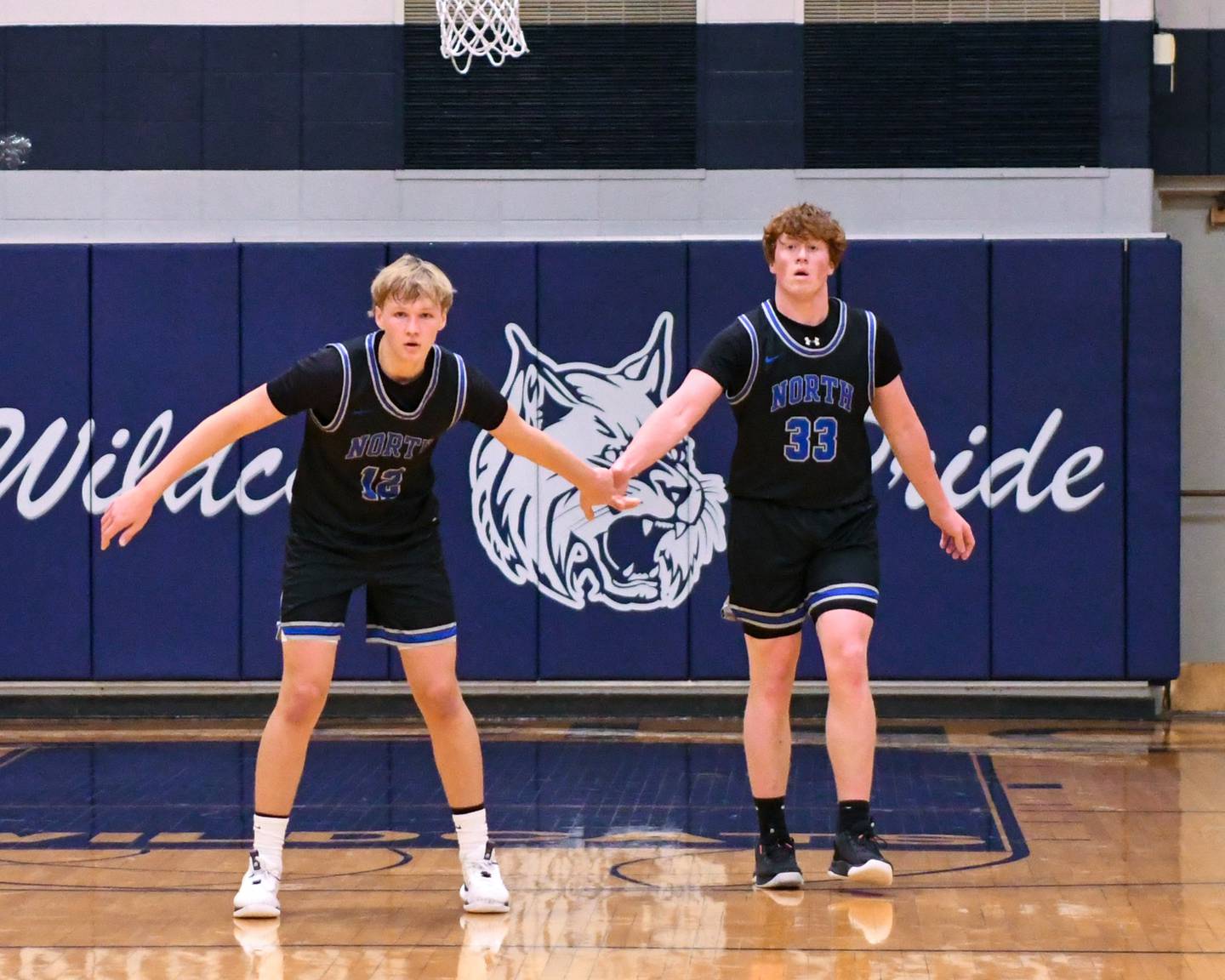 St. Charles North's Parker Reinke (12) gets congratulated by teammate Jake Furtney (33) after Parker makes a basket in the second quarter on Tuesday Nov 28, 2023, held at West Chicago Community High School.