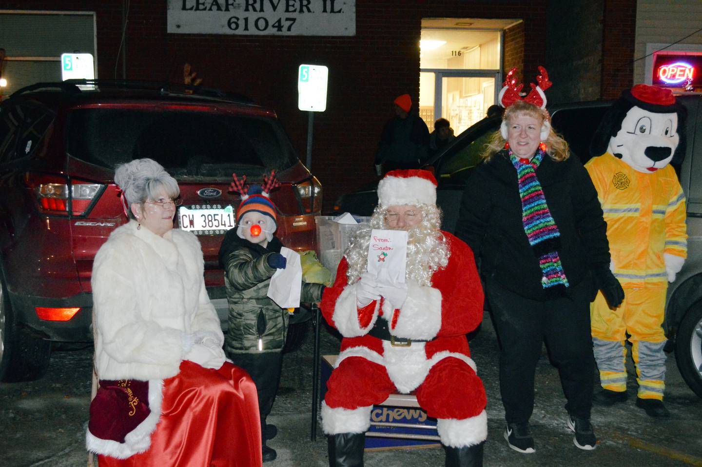 Lee Hammil, 5, of Forreston, stands between Santa and Mrs. Claus acting as their helper during the Dec. 17 Leaf River Christmas celebration. Dawn Plock, a member of the Leaf River Fire Department board, is to the right. The fire department helped organize the meet-and-greet.