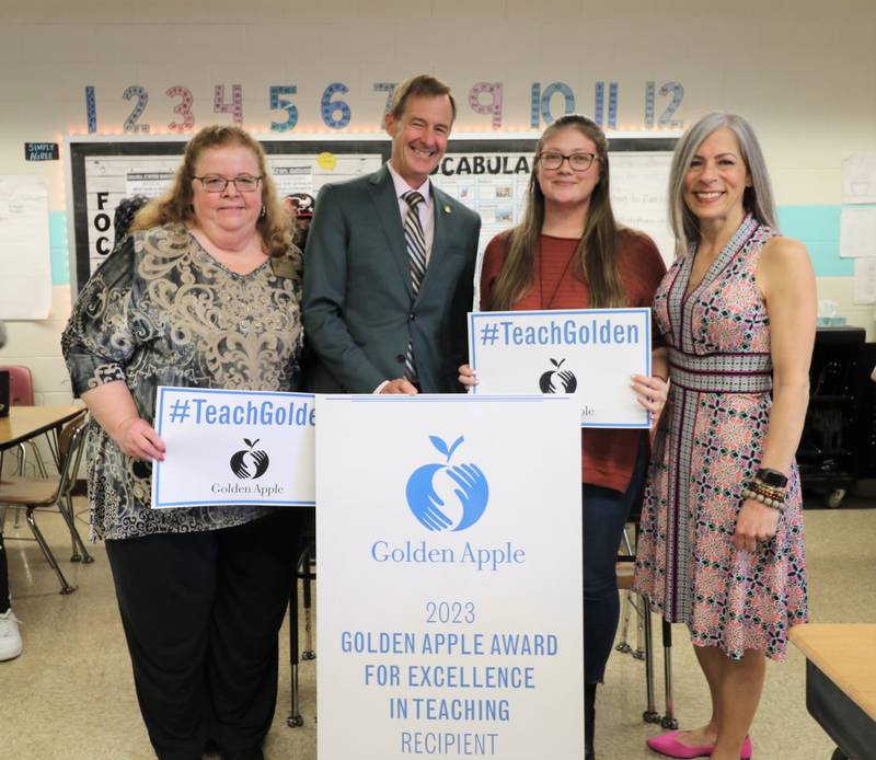 Superintendent Theresa Rouse, (left), President of the Golden Apple Foundation Alan Mather, Woodland Elementary School teacher Chelsea Young) and Woodland Elementary School Principal Kim Gordon were part of the surprise announcement that Young had received a Golden Apple Award for Excellence in Teaching.