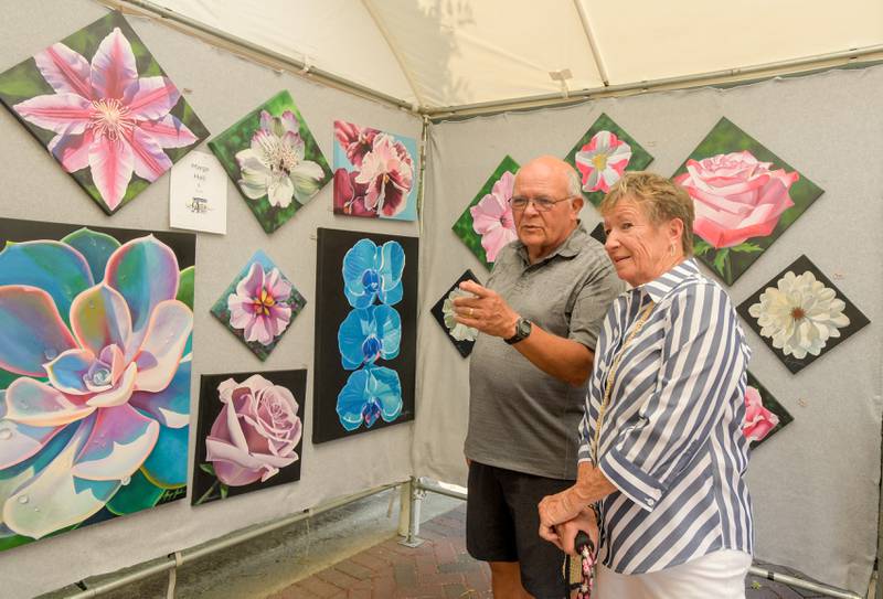 Rod Irey and Lee Anderson of Winfield shop for some art work during the Geneva Arts Fair along Third Street on Saturday, July 27, 2024.