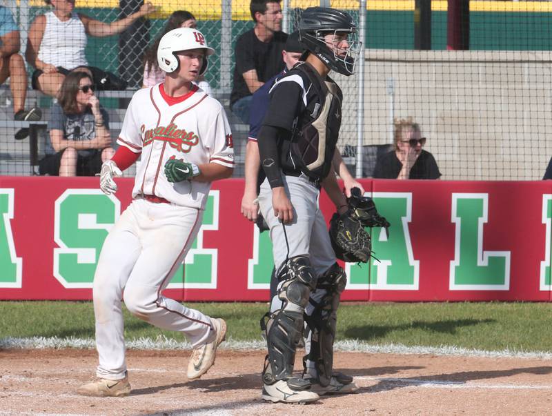 L-P's Jackson Piecha crosses home plate as Kaneland catcher Nate Campbell watches the play on Tuesday, May 13, 2025 at Huby Sarver Field at the L-P Athletic Complex in La Salle.