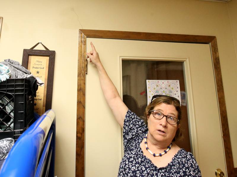 Carol Alcorn, executive director at Public Action to Deliver Shelter, points to a structure crack above a doorway at the homeless shelter on Tuesday, May 28, 2024, in Ottawa. U.S. Rep. Lauren Underwood, D-Naperville, is seeking a $1.25 million grant for a new 11,000 square foot building at the current PADS site in Ottawa in the next federal budget.