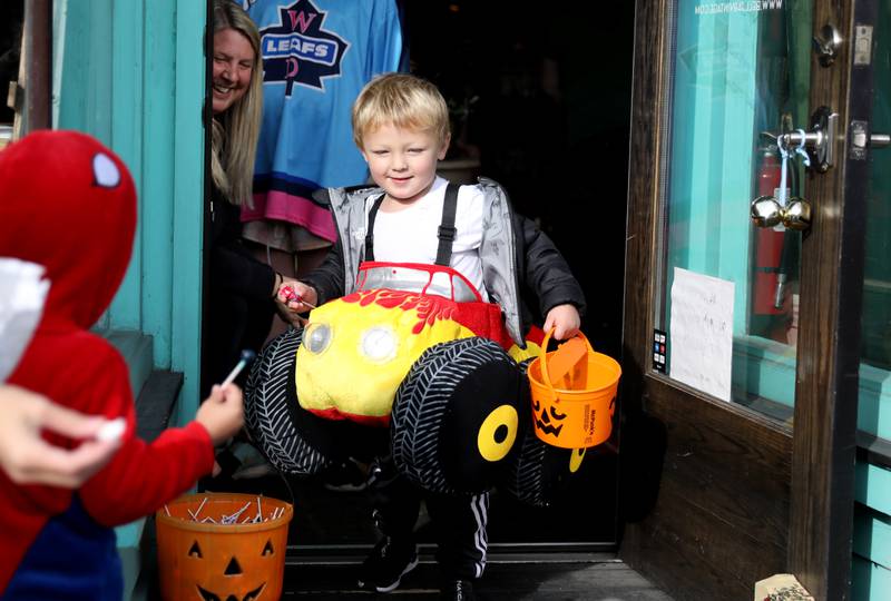 Austin Gonzalez, 3, exits a Geneva business while trick-or-treating on Thursday, Oct. 27, 2022.