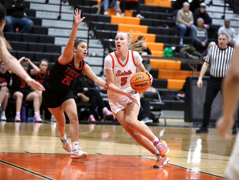 St. Charles East's Brooklyn Schilb drives toward the basket past Wheaton Warrenville South's Lucy Jethani during a game on Tuesday, Feb. 11, 2025 in St. Charles.