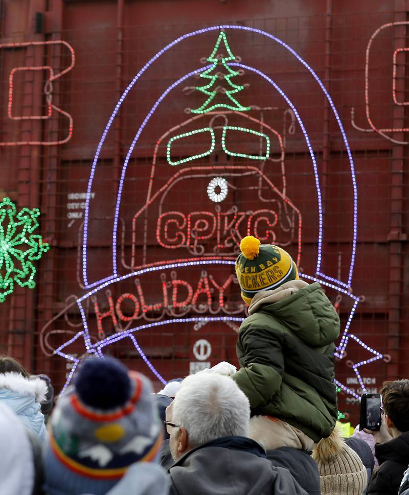 A boys sits on his dad’s shoulder as they watch the Canadian Pacific Kansas City Railway 2024 Holiday Train on Wednesday Nov. 27, 2024, as the train pulls into Pingree Grove. The holiday train raised food and monetary donations for the D300 Food Pantry during its stop in Pingree Grove.