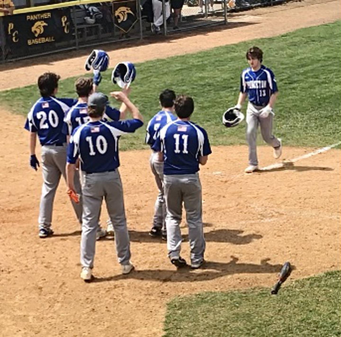 Ryan Brucker is greeted at home after hitting a three-runner in the sixth inning Saturday at Putnam County.