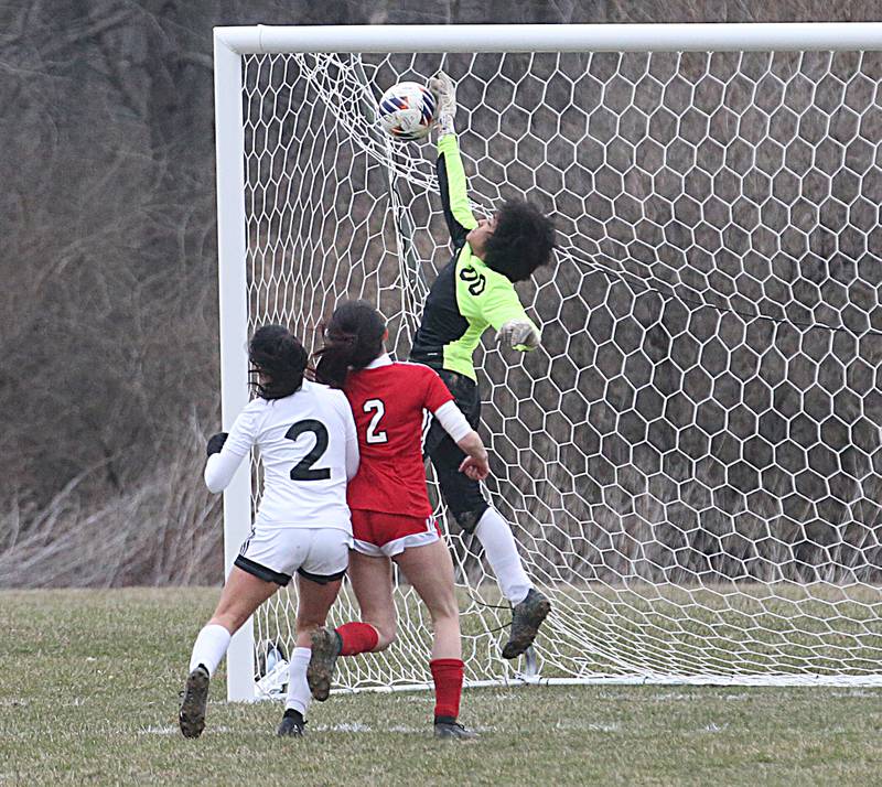 La Salle-Peru keeper Aurora Reed (00) punches away a Streator shot as teammate Vicky Tejada (in white) and Streator's Ady Lopez (in red) follow the ball into the box Friday, March 24, 2023, at the Streator Family YMCA.