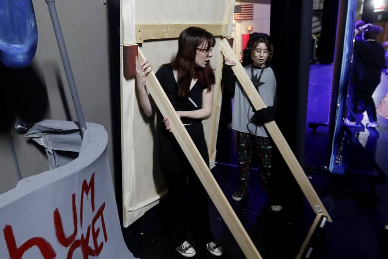 Kennedy Detour and Lila McGovern move a prop backstage before a rehearsal for the McHenry Community High School’s production of “The SpongeBob Musical” on Tuesday, March 7, 2023, at the school’s Upper Campus.