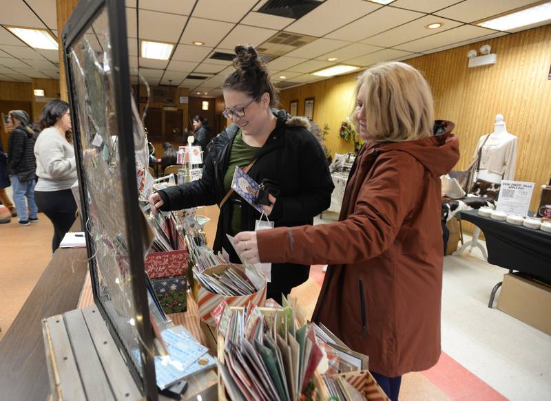 (left) Melyssa Greenacre of Carol Stream and Teresa Otake of Lombard pick out Holiday cards while shopping at the Berwyn Shops Holiday Pop-Up Market Saturday Dec 10, 2022.