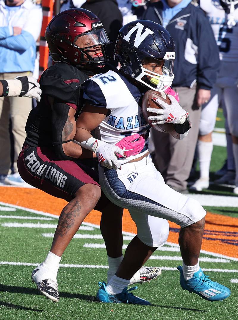 Nazareth's Edward McClain Jr. tries to pull away from a Peoria defender during their IHSA Class 5A state championship game Saturday, Nov. 26, 2022, in Memorial Stadium at the University of Illinois in Champaign.