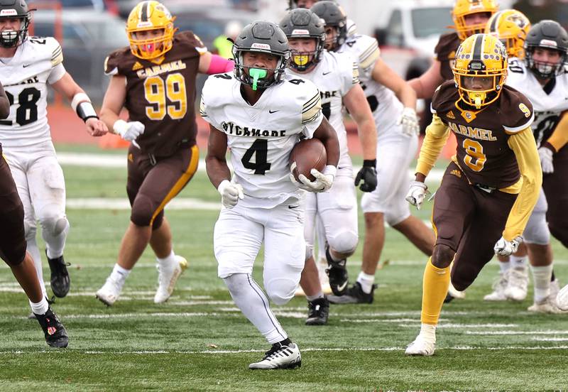 Sycamore's Tyler Curtis breaks through the Carmel defensive line on his way to a touchdown during their Class 5A second round playoff game Saturday, Nov. 5, 2022, at Carmel Catholic High School in Mundelein.