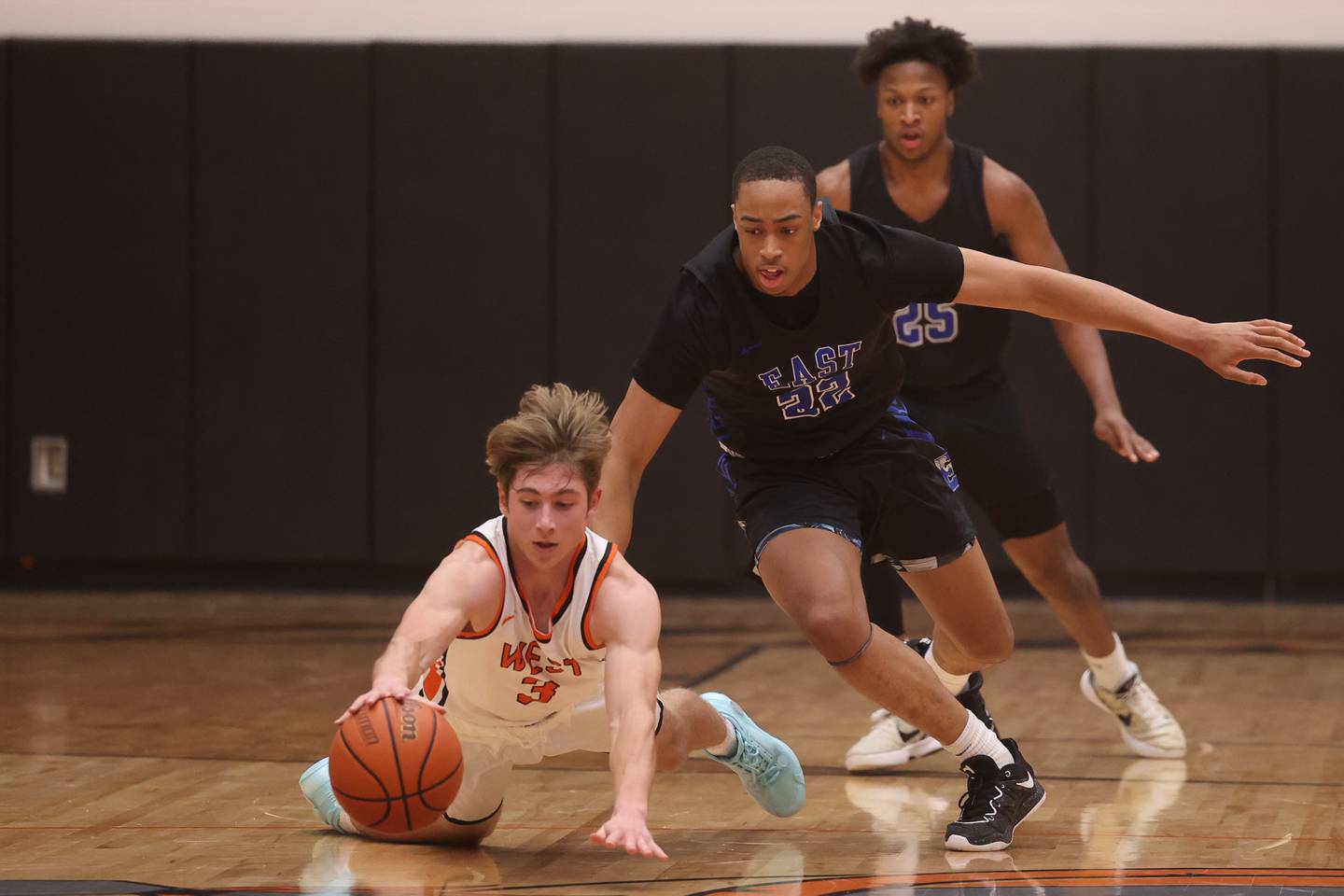 against Lincoln-Way West’s Jacob Willis beats Lincoln-Way East’s Kyle Olagbegi to the loose ball.