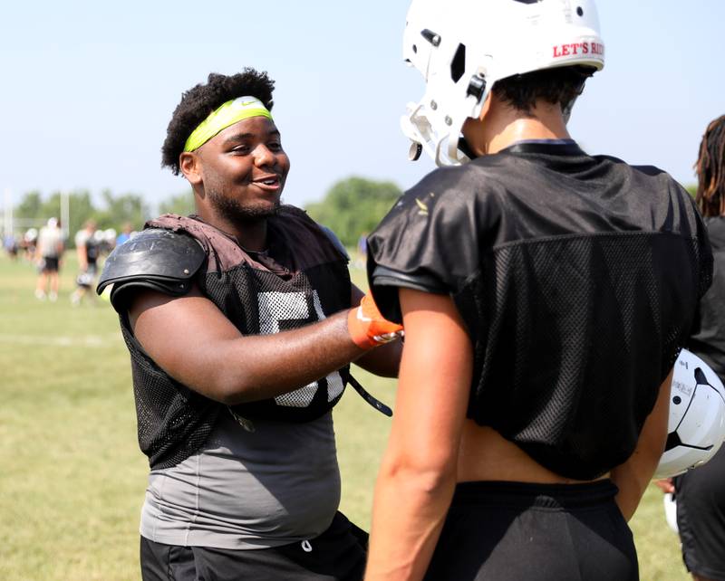 Glenbard South’s Cecil Tousant laughs with his team during a joint practice with Sterling and Oswego East football teams on Tuesday, July 15, 2025 in Oswego.