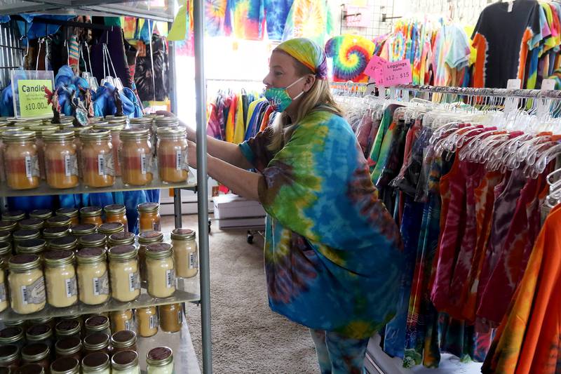 Kim, co-owner of Water Street Shoppe, tidies up the shelves and racks at her store on Court Street on Thursday, April 15, 2021, in McHenry.
