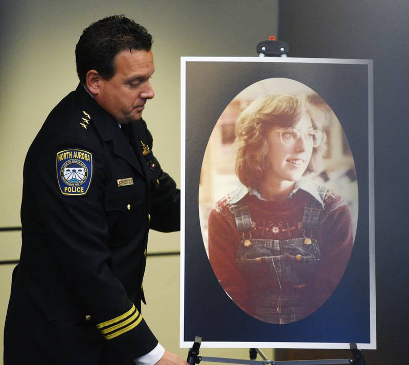 North Aurora Police Chief Joe DeLeo adjusts the positioning of a photo of Kathy Halle prior to the start of a press conference Wednesday. The North Aurora Police Department and the Kane County States’s Attorney’s Office announced that they have determined that the late Bruce Lindahl, who is suspected in several other 1970s murders, is person who killed 19-year old Halle in March, 1979.