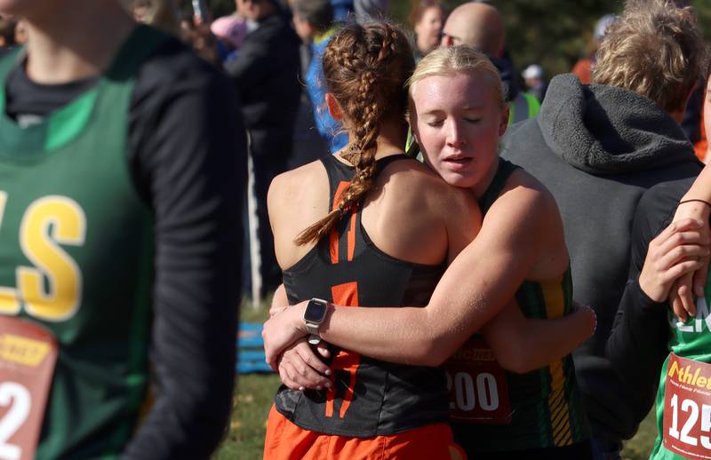 Crystal Lake Central’s Hadley Ferrero and Crystal Lake South’s Abby Machesky (facing) embrace after a Class 2A Sectional Cross Country Meet at Emricson Park in Woodstock Saturday.