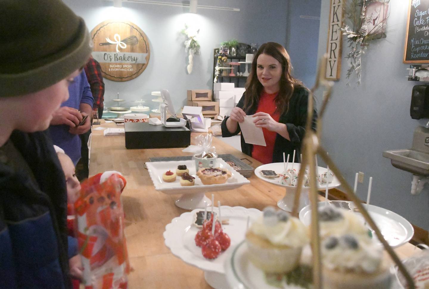 Olivia Gorzny serves customers during Oregon's Candlelight Walk on Nov. 26. Her store, O's Bakery, was one of the stores taking part in the evening event.