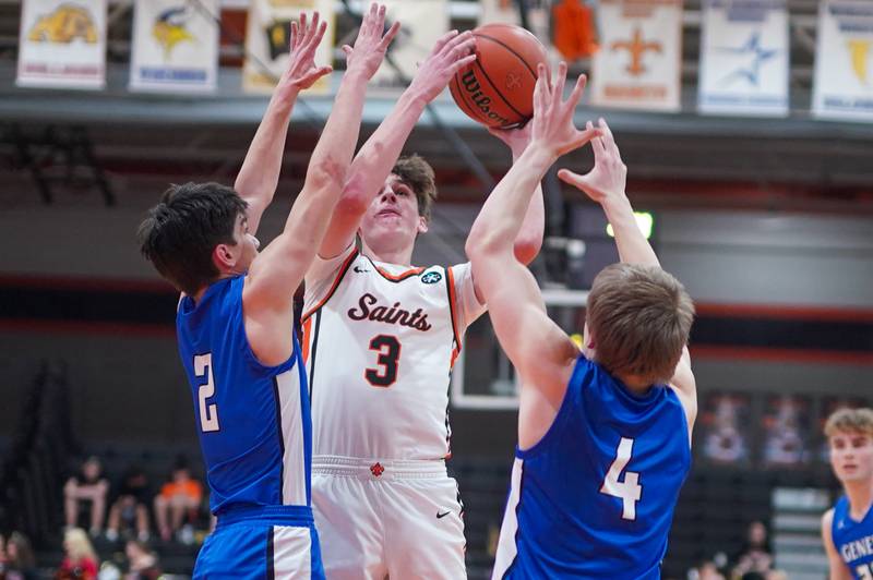 St. Charles East's Marco Klebosits (3) shoots the ball in the post over Geneva’s Gabe Jensen (2) and Brady Kafka (4) during a basketball game at St. Charles East High School on Friday, Feb 9, 2024.