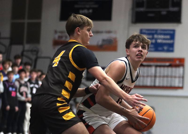 McHenry’s Caleb Jett, right, looks for the hoop as Jacobs’ Nolan Roper defends in varsity basketball on Wednesday, Dec. 4, 2024 at McHenry High School in McHenry.