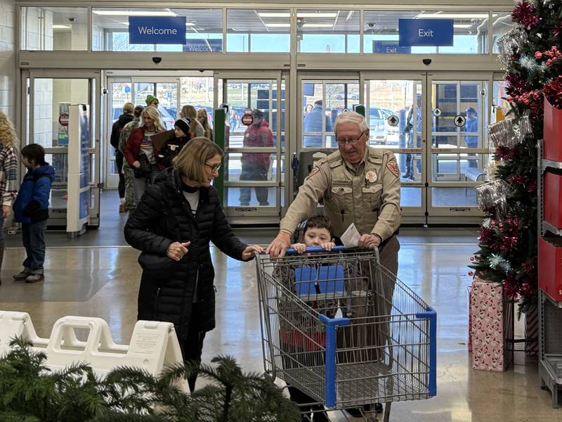 Joe Goolsby from the Grundy County Sheriff's Office and his wife Mary enter Walmart with Dallas to take him shopping for the Shop with a Local Hero event.