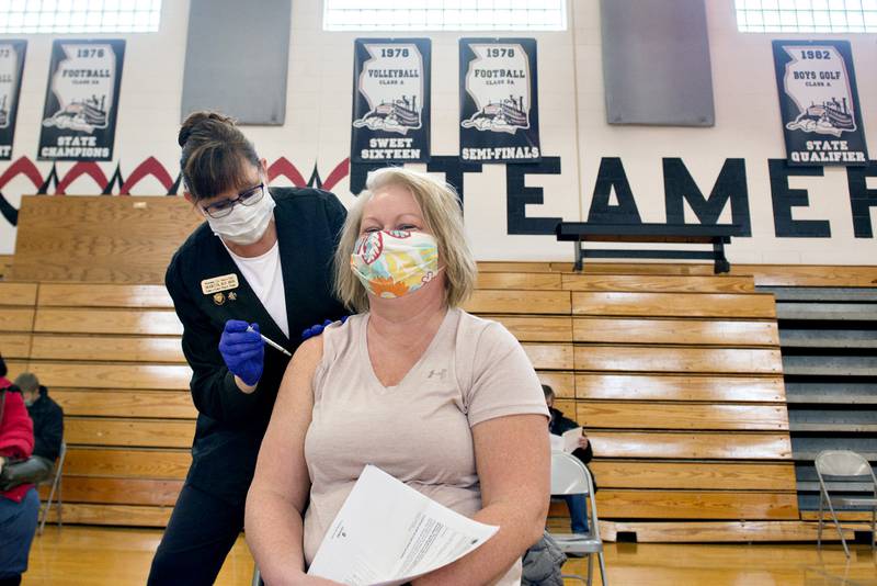 Jackie Davis, an employee at Sterling Systems and Controls, is vaccinated by Marcia Widolff of the Whiteside County Health Department Wednesday morning at Fulton High School. The county set up the vaccination day to inoculate teachers, school staff and manufacturing employees.
