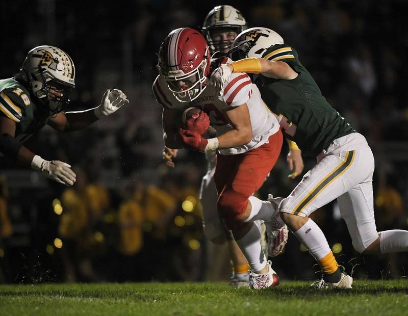 Naperville Central's Aiden Clark drags the Waubonsie Valley defense into the end zone for a touchdown in a football game in Aurora on Friday, September 15, 2023.