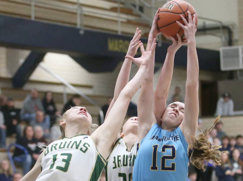 Marquette's Lilly Craig grabs a rebound over St. Bede's Ashlyn Ehm and teammate Lili McClain during the Class 1A Regional semifinal game on Monday, Feb,. 12, 2024 in Bader Gym.