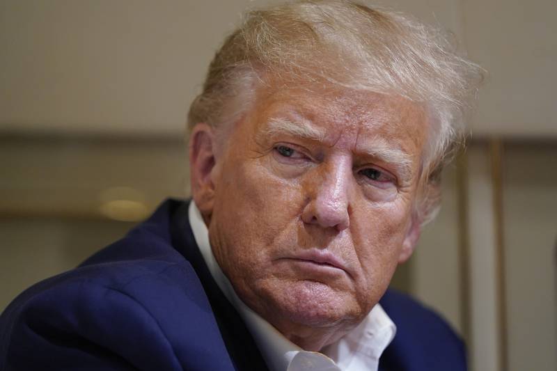 FILE - Former President Donald Trump listens as he speaks with reporters while in flight on his plane after a campaign rally at Waco Regional Airport, in Waco, Texas, on March 25, 2023, while en route to West Palm Beach, Fla. An audio recording that includes new details from a 2021 meeting in Bedminster, New Jersey, where former President Donald Trump discusses holding secret documents he did not declassify has been released. (AP Photo/Evan Vucci, File)