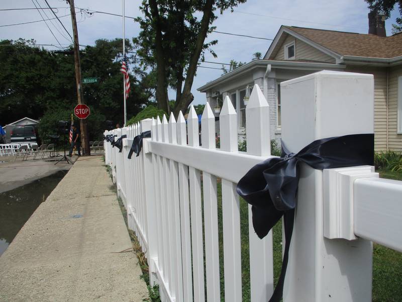 Black ribbons tied along the white picket fence posts at Jose Duenez Jr.'s boyhood home in Joliet serve to mourn his death in an Army training exercise in March in Lithuania. July 11, 2025