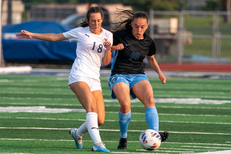 Wheaton Warrenville South's Ella McClatchy (18) challenges St. Charles North's Laney Stark (19) for the ball during the Class 3A girls soccer regional final at St. Charles North High School.