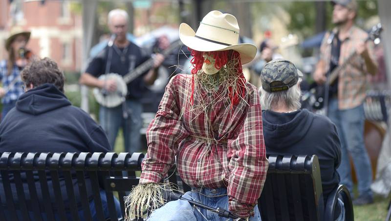 Scarecrow Fest goers as well as scarecrows listen Saturday, Sept. 28, 2024, to The Coffee Creek Bluegrass Band at Washington Square during the annual Scarecrow Fest in Ottawa.