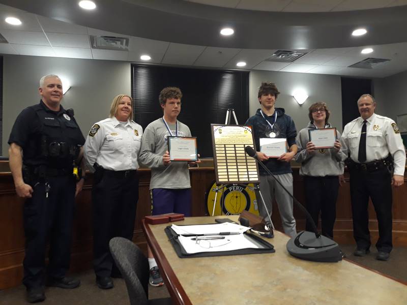 (Third from left) Logan Arkels, Brandon Stopka and Adam Odell were honored by Peru Police Officer Matt Peters (left), Deputy Chief Sarah Raymond and Peru Police Chief Bob Pyszka on Monday, Feb. 28, 2022, for calling 9-1-1 to save a woman's life Jan. 25.